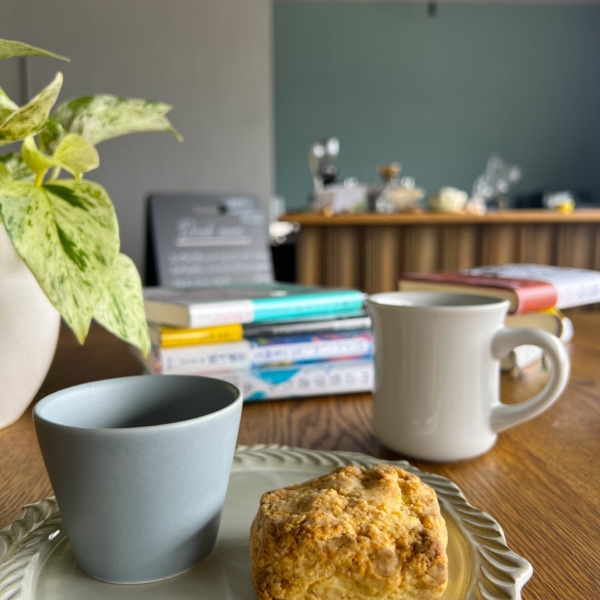 スコーンとコーヒーと奥に積み上がった本